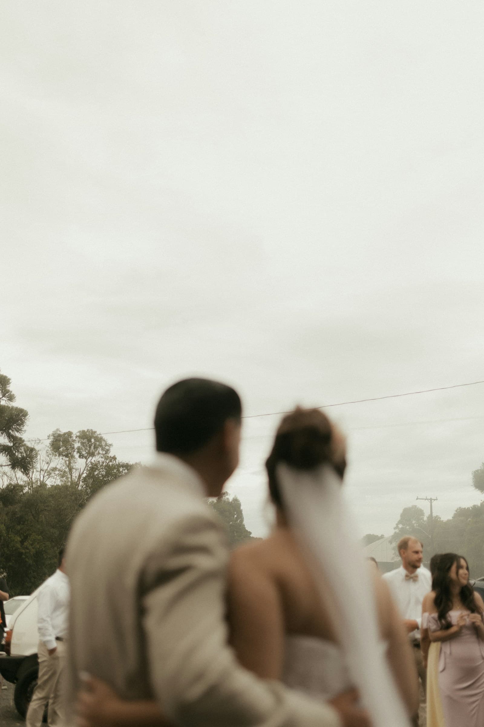 Wedding couple and guests gathering outdoors
